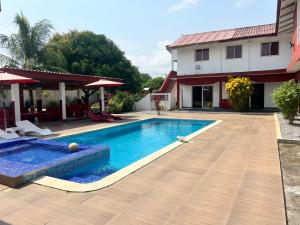 a swimming pool in a yard next to a house at Beautiful Villa with Swimming Pool in Assinie in Mafia