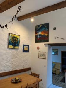 een kamer met een tafel en schilderijen aan de muur bij Le Mas De La Siffleuse in Jaujac