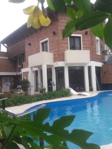 una casa con piscina frente a ella en Costanera Goya Apart & Hotel en Goya