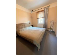 ein Schlafzimmer mit einem Bett, einem Fenster und einem Stuhl in der Unterkunft Ferienwohnung BALOMO, nur 650m zum Strand in Zinnowitz