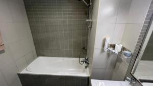 a bathroom with a shower with a tub and a sink at Luxury Twin Room Ajman One Tower in Ajman 