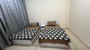 two beds in a room with a window at Luxury Twin Room Ajman One Tower in Ajman 