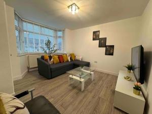 a living room with a couch and a table at The Ideal Beautiful 3-Bed House in Birmingham in Birmingham