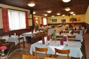 uma sala de jantar com mesas e cadeiras brancas em Gasthof zur Linde em Sankt Andrä bei Frauenkirchen