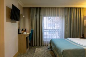 Grand Wonne Hotel في أنقرة: غرفه فندقيه بسرير ونافذه