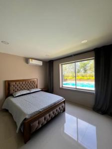 - une chambre avec un lit et une grande fenêtre dans l'établissement Elegante casa campestre con Piscina, à Valledupar