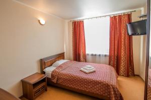 ein kleines Schlafzimmer mit einem Bett und einem Fenster in der Unterkunft Готель Україна in Lokhvytsya
