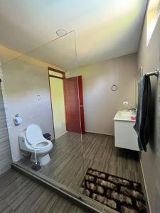 La salle de bains est pourvue de toilettes et d'une douche en verre. dans l'établissement Elegante casa campestre con Piscina, à Valledupar