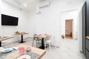 a living room with tables and chairs and a tv at L'isola che c'è in Cagliari