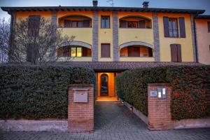 a large house with a brick gate in front of it at Affittacamere L'Agorà in Piacenza
