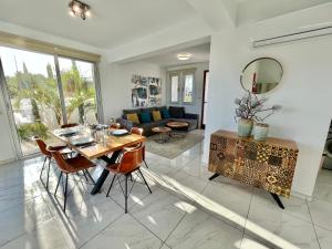 ein Esszimmer und ein Wohnzimmer mit Tisch und Stühlen in der Unterkunft Alasia Villa ll Kapparis in Paralimni
