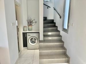 eine Treppe mit Waschmaschine und Trockner in einem Haus in der Unterkunft Alasia Villa ll Kapparis in Paralimni