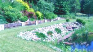 a park with a pond and a bench in the grass at Agroturystyka nad Wdą in Wieck