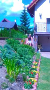 a woman sitting on a bench in a garden at Agroturystyka nad Wdą in Wieck
