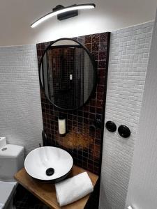 W łazience znajduje się umywalka i lustro. w obiekcie Night o'clock Business and Spa Aparts w mieście Opole