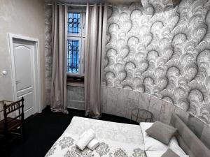 a bedroom with a bed and a wall with a window at Night o'clock Business and Spa Aparts in Opole