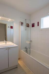 uma casa de banho com um chuveiro, um lavatório e uma banheira em Les Terrasses du Lac J43 em Aureilhan