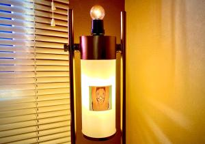 a lamp with a picture of a man next to a window at La Fuente House in Constanza