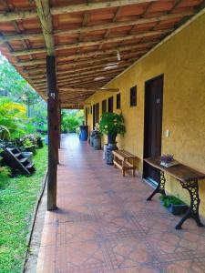 un patio esterno con panchine e tetto in legno di Pousada Paineira a São Gonçalo do Rio das Pedras