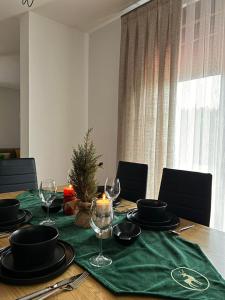 a table with a christmas tree and wine glasses on it at Luxurious House for Rent in Prishtinë
