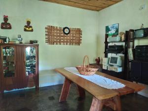 a room with a table and a clock on the wall at Pousada Paineira in São Gonçalo do Rio das Pedras