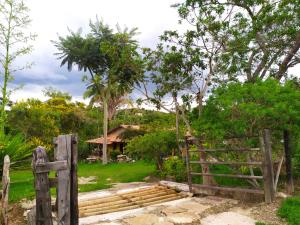 a gate to a garden with a house in the background at Pousada Paineira in São Gonçalo do Rio das Pedras