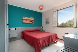 モンテパオーネにあるResidence Calaghenaのベッドルーム1室(赤いベッド1台、窓付)