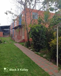 una pasarela de ladrillo frente a un edificio en Córest Hotel B&B, en Tocancipá