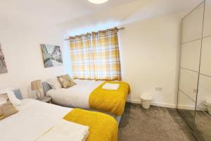 two beds in a small room with a window at Paradigm House, Delightful 2-Bedroom Flat 4, Oxford in Oxford