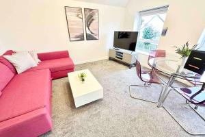 a living room with a red couch and a glass table at Paradigm House, Delightful 2-Bedroom Flat 4, Oxford in Oxford