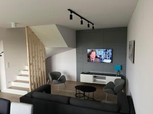a living room with a couch and a tv on a wall at Apartament Błękitna Mewa Mosty in Mosty