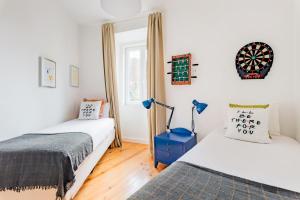 a bedroom with two beds and a dartboard on the wall at Monica's Groove: a Friends' Inspired Apartment in Lisbon