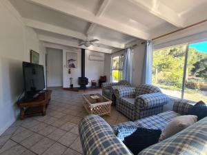 ein Wohnzimmer mit Sofas und einem Flachbild-TV in der Unterkunft Kookaburra Lodge in Lock Sport