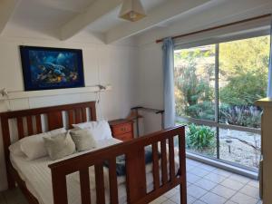 ein Schlafzimmer mit einem Bett und einem großen Fenster in der Unterkunft Kookaburra Lodge in Lock Sport