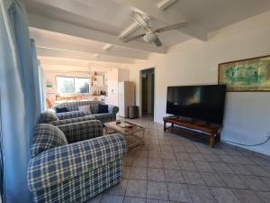 ein Wohnzimmer mit 2 Sofas und einem Flachbild-TV in der Unterkunft Kookaburra Lodge in Lock Sport