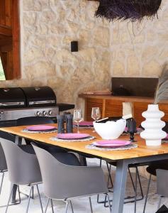 una mesa de madera con sillas, platos y cuencos. en Valmont Luxury Chalet, 