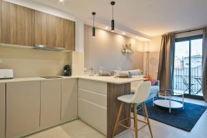 a kitchen with white cabinets and a table and chairs at YOUR HOME- Apartment Camp Nou 2b in Hospitalet de Llobregat