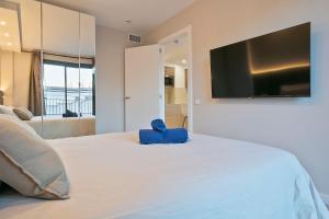 a bedroom with a large bed with a television on the wall at YOUR HOME- Apartment Camp Nou 2b in Hospitalet de Llobregat