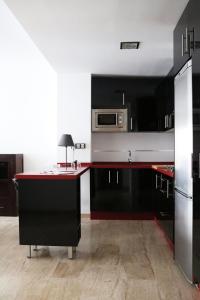 cocina con armarios negros y microondas en Suite Apartment City Center - Aloha Sevilla, en Sevilla