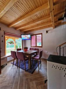 a dining room with a wooden table and chairs at Stara pruga Jaz 2 in Višegrad