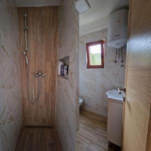 een badkamer met een douche en een toilet bij Stara pruga Jaz 2 in Višegrad