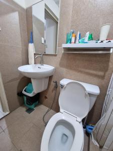 a bathroom with a toilet and a sink at Casa Simbé - Château Elyseé Staycation Parañaque in Manila