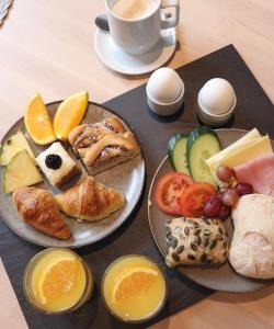 una mesa con dos platos de comida y una taza de café en Hotell Rådhuset en Lidköping