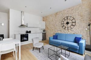 salon z niebieską kanapą i kuchnią w obiekcie Bright typical apartment-TiquetonneChâtelet w Paryżu
