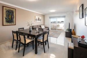 een eetkamer en een woonkamer met een tafel en stoelen bij Apartment Mar a Vista in Portimão