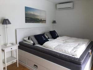 ein Bett mit weißer Bettwäsche und Kissen in einem Schlafzimmer in der Unterkunft Beach Home, Köpingsvik in Köpingsvik