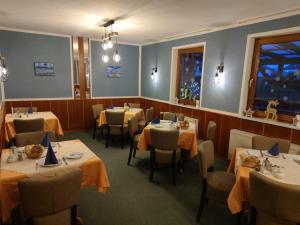 un ristorante con tavoli e sedie in una stanza di Pension Richter a Ueckeritz