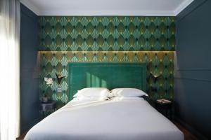 a bedroom with a large bed with a green wall at Seven Suites in Rome