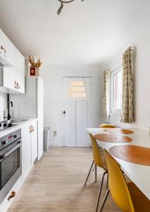 a kitchen with a dining table and yellow chairs at Vitaflow logies in Koksijde