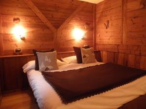 una camera da letto con un grande letto in una camera in legno di B&B Lepetitnid a Valtournenche